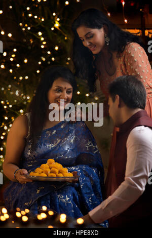 Femme avec sa fille et son gendre célébrant Diwali Banque D'Images