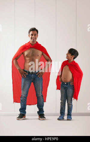 Smiling young man and boy in costume de superman Banque D'Images