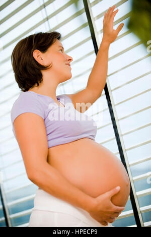 Schwangere Frau , parution modèle sieht aus dem Fenster - femme enceinte regarde par la fenêtre Banque D'Images