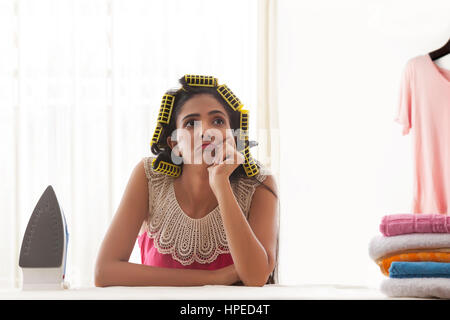 Jeune femme avec des joueurs assis à table à repasser Banque D'Images