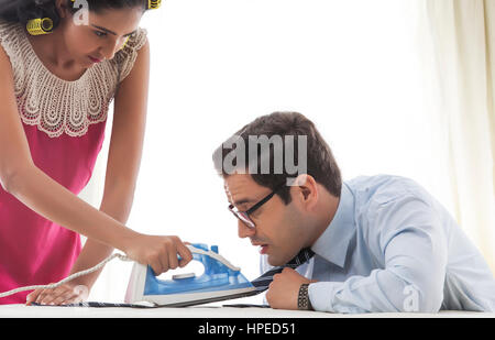 Jeune femme avec des bigoudis planche man's tie Banque D'Images