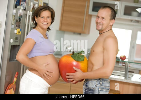 Schwangere Frau modèle libéré , Mann und mit grossem Apfel zwischen den Baeuchen - futurs parents avec big apple Banque D'Images