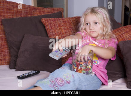 Suessigkeiten Maedchen mit Fernbedienung und beim Fernsehen - girl watching TV Banque D'Images