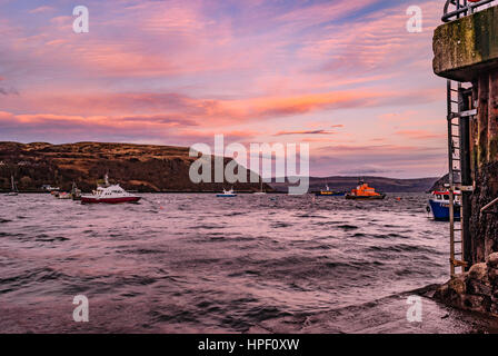 Avis de Rassay Sound du quai le port de Portree, Isle of Skye, Scotland, alors que le soleil descendait dans la soirée, avec les nuages orange et rose Banque D'Images