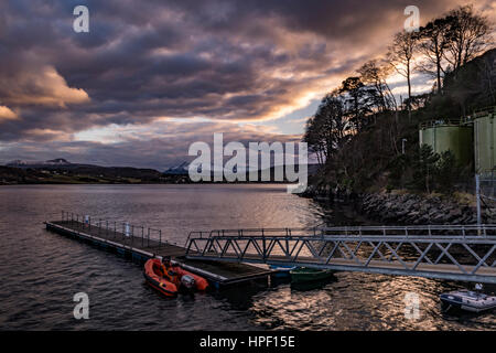 Montagnes Cuillin Hills, sur le Loch Portree, sur l'île de Skye, en Écosse, contre un ciel dramatique, en face de Portree Harbour landing stage. Banque D'Images