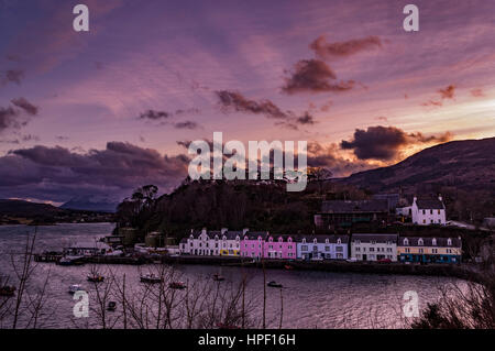 La rangée de maisons colorées sur le quai au port de Portree, Isle of Skye, Scotland. Les rayons du soleil à travers les nuages en couches, avec Cuillin Hills en arrière-plan. Banque D'Images