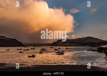 Avis de Rassay Sound du quai le port de Portree, Isle of Skye, Scotland, alors que le soleil descendait dans la soirée. Reflétant le soleil orange. Banque D'Images