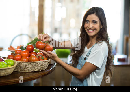 Portrait d'une femme le choix de tomates fraîches du panier Banque D'Images