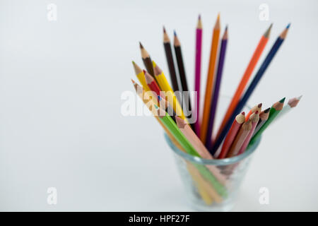 Close-up of Colored Pencils conservés dans du verre sur fond blanc Banque D'Images