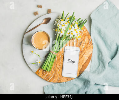 Tasse de café du matin, seau de fleurs de printemps et d'un téléphone mobile avec le texte aujourd'hui sur le service à bord en marbre gris clair sur arrière-plan, Vue de dessus. Matin Banque D'Images