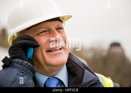 Ingénieur civil en conversation sur téléphone cellulaire. Banque D'Images