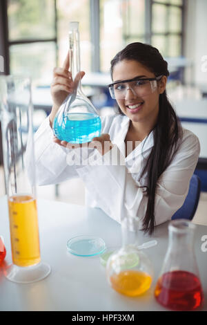 Portrait of happy lycéenne faisant une expérience chimique en laboratoire à l'école Banque D'Images