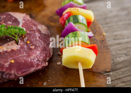 Close-up de hacher de surlonge avec brochette de légumes sur plateau en bois Banque D'Images