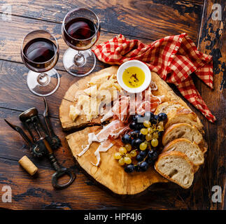 Jambon Apéritif et assiette de fromage avec du vin sur fond de table en bois Banque D'Images