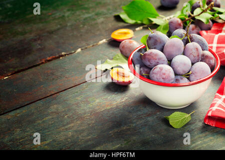 Les prunes sucrées sur fond de bois.bio fruits sains. Focus sélectif. Arrière-plan de l'espace de copie Banque D'Images