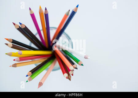 Close-up of Colored Pencils conservés dans du verre sur fond blanc Banque D'Images