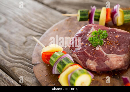 Close-up de hacher de surlonge avec brochette de légumes sur plateau en bois Banque D'Images