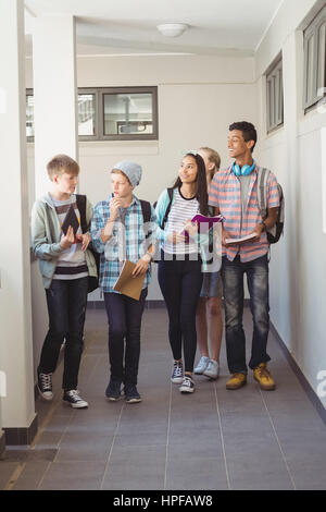 Groupe de camarade de marcher dans le couloir à l'école Banque D'Images