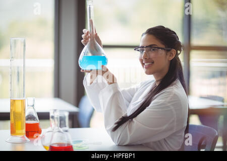 Portrait of happy lycéenne faisant une expérience chimique en laboratoire à l'école Banque D'Images