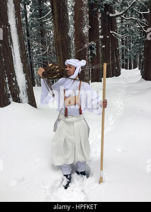 Les yamabushi japonais Takehiro ascétique montagne Miura souffle une coquille de conque corne dans une forêt couverte de neige dans la province de Yamagata, Japon, le 15 février 2017. Les moines et les membres de l'laïcs ont retiré dans les montagnes de la région à vivre une vie ascétique dans les rituels et la prière de quelque 1300 ans. Photo : Lars/dpa Nicolaysen Banque D'Images