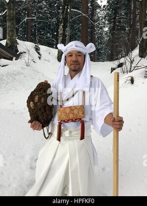 Les yamabushi japonais Takehiro ascétique de montagne est titulaire d'une conque de Miura dans la forêt couverte de neige dans la province de Yamagata, Japon, le 15 février 2017. Les moines et les membres de l'laïcs ont retiré dans les montagnes de la région à vivre une vie ascétique dans les rituels et la prière de quelque 1300 ans. Photo : Lars/dpa Nicolaysen Banque D'Images