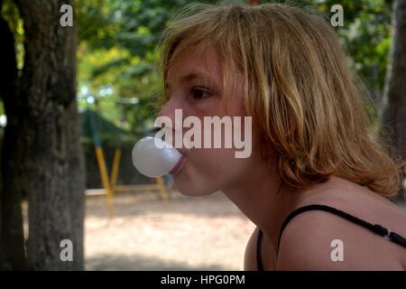 Le côté fille fait une petite bulle de chewing-gum Banque D'Images