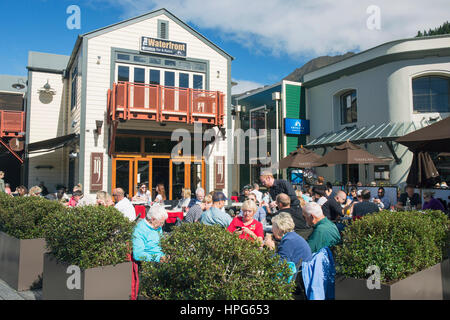 Queenstown, Otago, Nouvelle-Zélande. Les clients sur la terrasse animée de Pier 19, un restaurant et un café au bord du lac. Banque D'Images