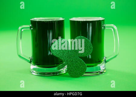 St Patricks Day deux chopes de bière verte avec shamrock sur fond vert Banque D'Images