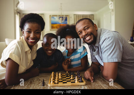Portrait de famille en jouant aux échecs ensemble à la maison dans la salle de séjour à la maison