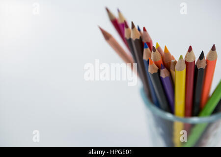 Close-up of Colored Pencils conservés dans du verre sur fond blanc Banque D'Images