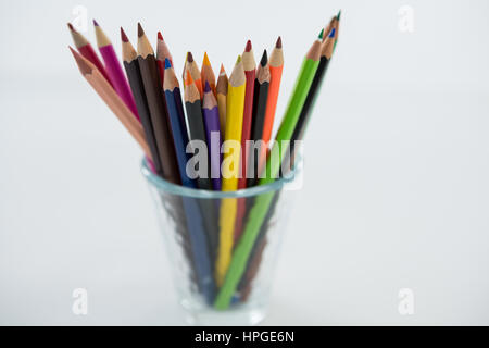 Close-up of Colored Pencils conservés dans du verre sur fond blanc Banque D'Images