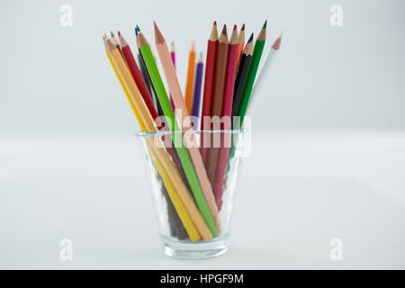 Close-up of Colored Pencils conservés dans du verre sur fond blanc Banque D'Images