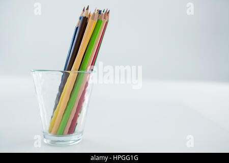 Close-up of Colored Pencils conservés dans du verre sur fond blanc Banque D'Images