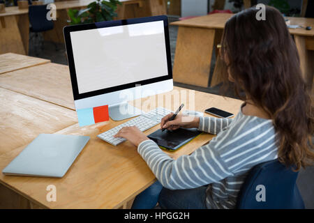 Femme graphic designer working at desk in creative office Banque D'Images