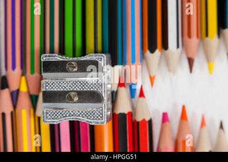 Close-up de crayons de couleur et taille-crayons sur fond blanc Banque D'Images