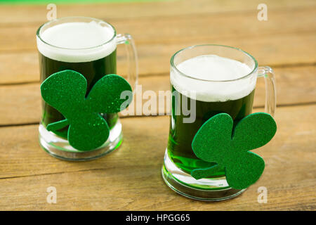 St Patricks Day deux chopes de bière verte avec shamrock sur surface en bois Banque D'Images