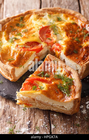 Délicieux gâteau en tranches de feta, tomates et fines herbes gros plan sur la table. La verticale Banque D'Images