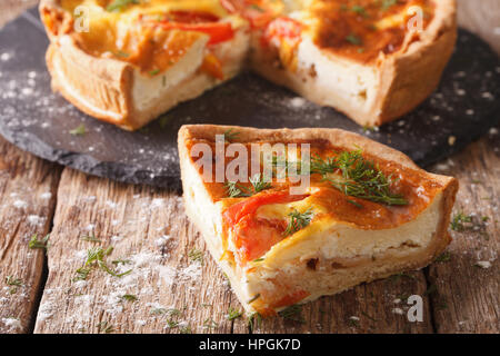 Freshly sliced pie à la feta, tomates et fines herbes libre sur la table horizontale. Banque D'Images