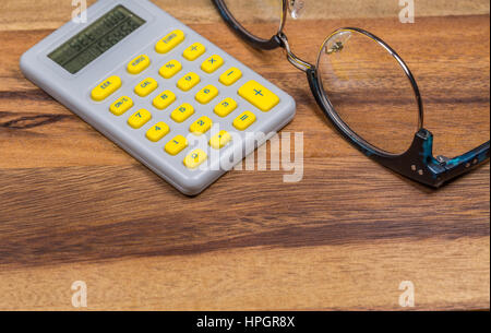 Les lunettes et Calculatrice sur table en bois Banque D'Images