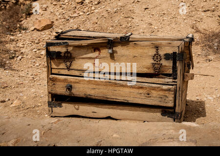 Un vieux coffre en bois usés météorologiques utilisés comme une échoppe de marché. Entouré par la poussière et les roches. Décorées avec des sangles en cuir et métal. Banque D'Images