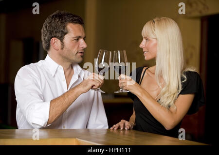 Parution du modèle , Mann und Frau mit Wein sitzen an der Bar - couple boit du vin au bar Banque D'Images