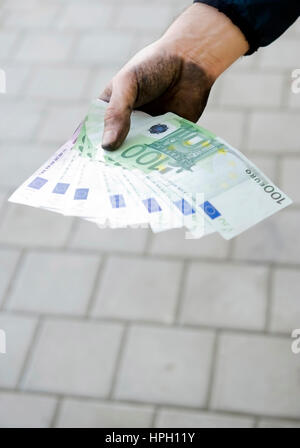 Parution du modèle , Symbolbild Schwarzgeld, Arbeiter mit schmutzigen Haenden haelt Geldscheine - symbolique pour l'argent noir Banque D'Images