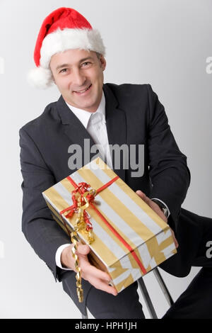 Geschaeftsmann modèle libéré , Weihnachtsmuetze mit und Weihnachtsgeschenk - business man avec cadeau de Noël et Noël cap Banque D'Images