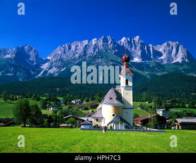 Les fleurs de printemps à aller avec son église d'oignon, Wilder Kaiser en arrière-plan, Tyrol, Autriche. Banque D'Images