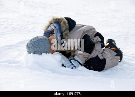 Junge steckt Kopf in den Schnee - garçon enfouit la tête dans la neige, modèle publié Banque D'Images