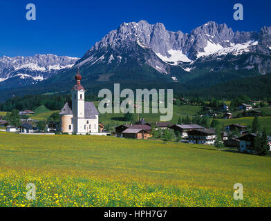 Les fleurs de printemps à aller avec son église d'oignon, Wilder Kaiser en arrière-plan, Tyrol, Autriche. Banque D'Images