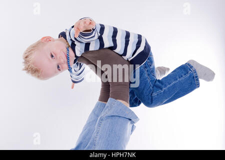 Vater hebt Jungen mit Füssen dans die Luft - le père et le garçon jouant, modèle publié Banque D'Images