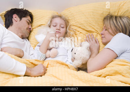 Die Eltern und Tochter dormir dans un Bett - parents et sa fille dormir dans un lit, modèle publié Banque D'Images