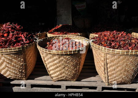 Grands paniers de piments rouges séchés à vendre dans un marché à la périphérie de Yangon, Myanmar. Banque D'Images