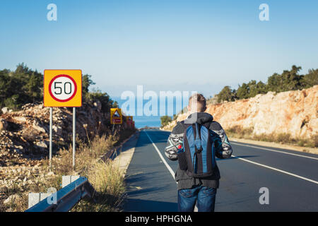 Jeune homme à l'auto-stop travel l'itinéraire. Banque D'Images